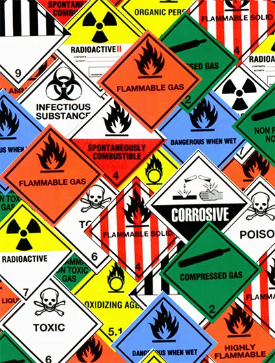 Collection of hazardous waste classification labels showing toxic, flammable, infectious and compressed gas warnings in the UK (2025).